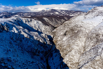 Winter mountain landscape with a snowy river valley shot from an aerial drone
