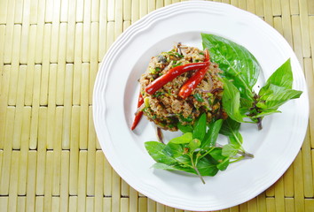 spicy minced catfish with herb topping red chili Thai salad on plate