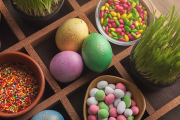 Obraz na płótnie Canvas Colored easter eggs, grass and small candies in frame