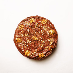 Homemade chocolate cake with nuts, white background, top view