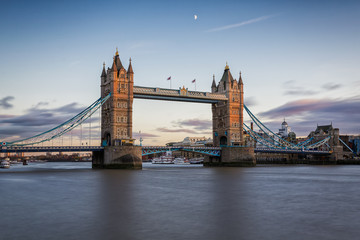 London's Tower Bridge at sunset with half moon