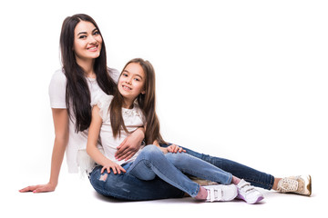 Portrait of happy white mother and young daughter lying on the floor isolated on white background. Happy family people concept.