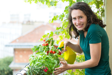 Young woman hoping not killing her plant with chemistral product - Ecology and nature theme