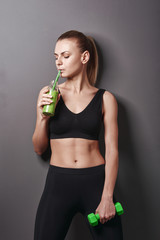 girl with dumbbells and smoothies. concept of healthy nutrition and sport. healthy lifestyle