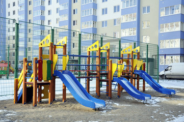 Children's complex of different swings in the courtyard of a multi-storey building. Bright and safe game that can be played by children.