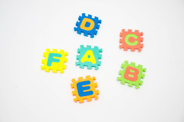 Colorful foam puzzle with word on a white background.