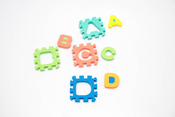 Colorful foam puzzle with word on a white background.