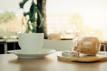 White hot coffee cup on wooden table on green background.