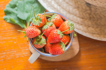 Strawberry in a glass on a wooden table.