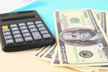 Finance concept : The United States hundred-dollar bills , calculator , bills.