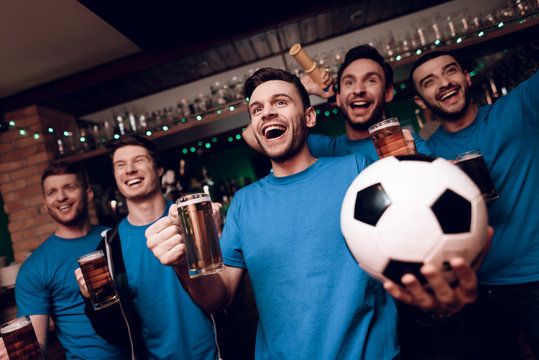 Five Soccer Fans Drinking Beer Celebrating And Cheering At Sports Bar.