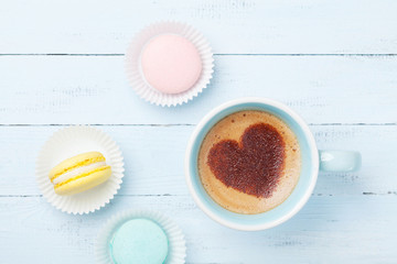 Cake macaron or macaroon and cup of coffee with heart on foam top view. Flat lay style.