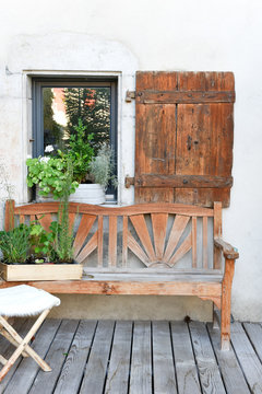 old wooden bench on a beautiful teak terrace of a renovated country house in a vintage atmosphere