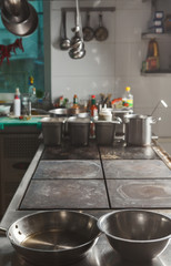 Modern restaurant kitchen interior with frying pans