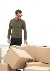 man looks at boxes in a new house