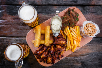 Assorted beer snacks with beer mugs