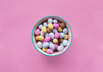 Easter chocolate colorful candy eggs on a pink background