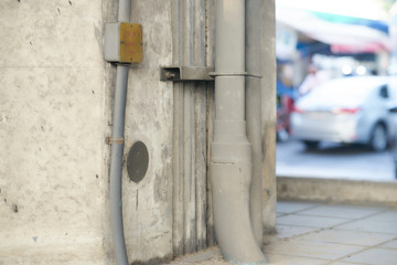 Water pipe on wall and electic line  on street with blur view