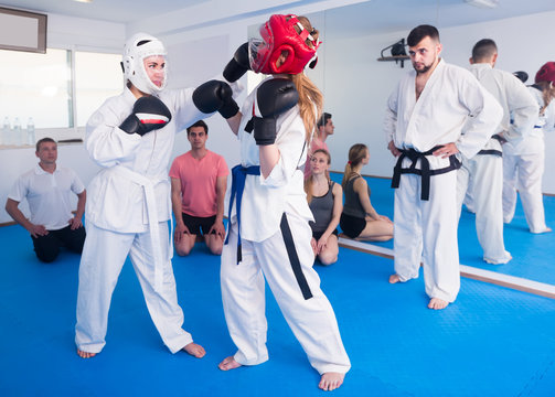 Women are practicing blows in sparring