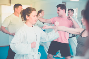 Fototapeta premium Young males and females are practicing new karate moves in pairs