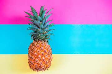 pineapple fruit on blue yellow and pink background