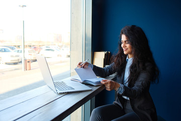 Woman sitting in coffee shop and writing notes