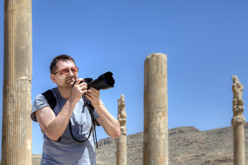 An independent traveler on his own journey photographs the ruins.