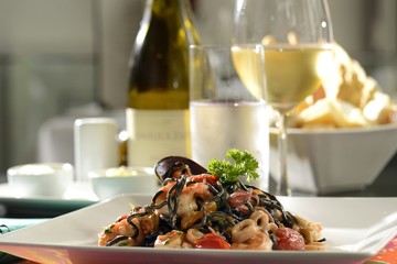 Tagliolini fresh pasta with squid ink, shrimp, cockles, clams and tomato sauce.