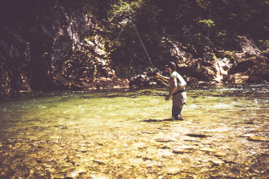 Fly fisherman flyfishing in river