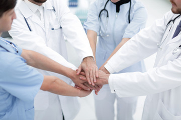 doctors holding hands together at hospital