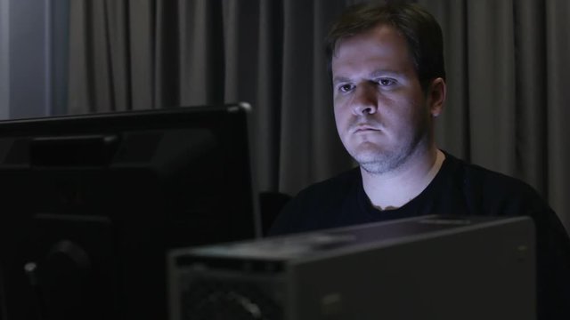 Man in dark office or lab using computer.

