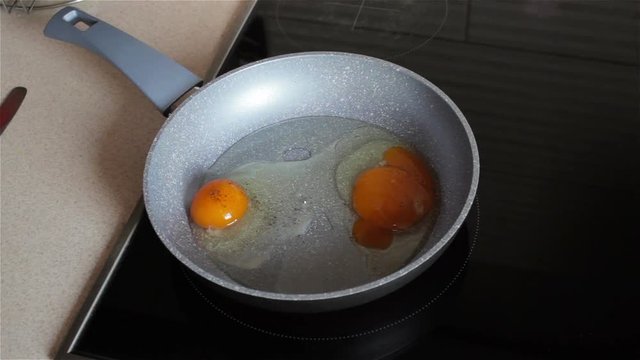 Sprinkle peppers on eggs,fry eggs in a pan on a built-in electric floor and sprinkle eggs with black pepper