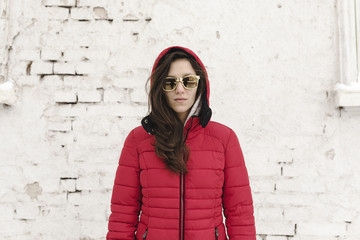 Winter snowy portrait of a young woman wearing red jacket