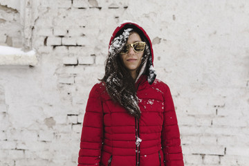 Winter snowy portrait of a young woman wearing red jacket