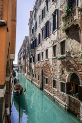 Narrow side canal with boats in Venice, Symbol of Venice, Venetian transport boats, Classical street in Venice