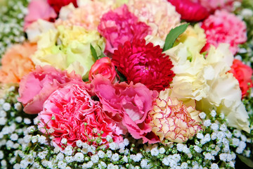 A bouquet of carnations with small white flowers