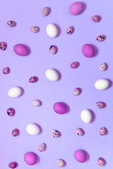 White, violet and quail easter eggs on violet background, copy space. Healthy food concept. Top view, flat lay. Happy Easter concept