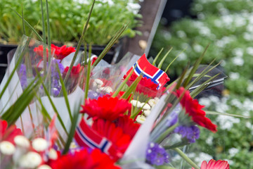 Norwegian Constitution Day is the national day of Norway and is an official public holiday observed on May 17. Flowers and flags of Norway