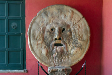 Carved stone human face Bocca della Verita or Mouth of Truth sculpture indoors in Rome