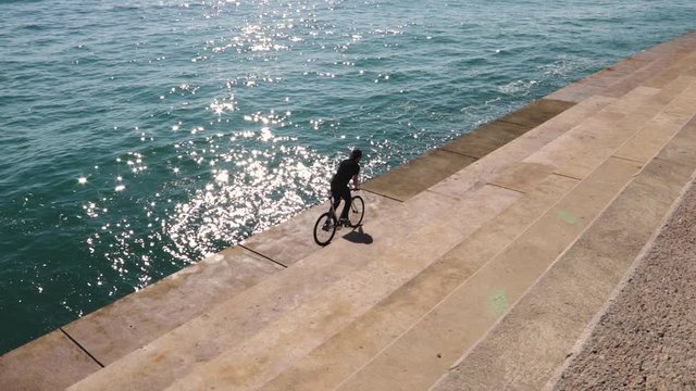 Bikers goes with a fixie near the water in Barcelona