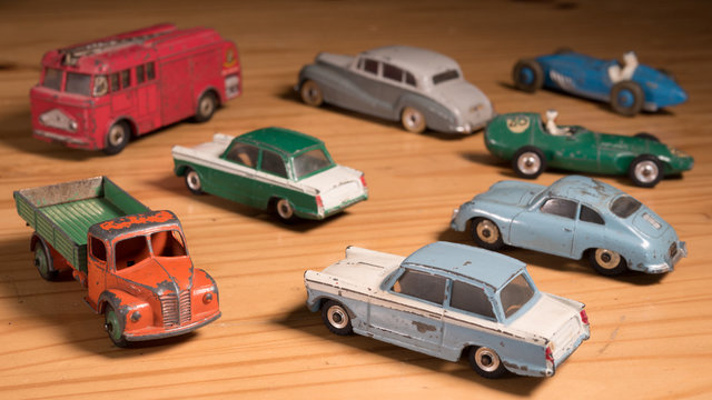 Old retro metal toy cars on wooden table 