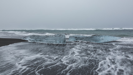 Ice on the black volcanic beach near Jokulsarlon glacier lagoon, winter Iceland