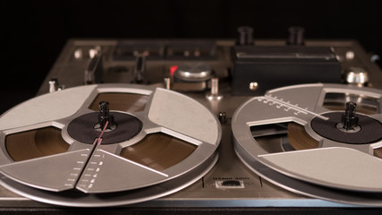 Vintage Reel to Reel tape recorder playing music close up of reel