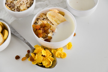 Breakfast in glass Cup: homemade granola, banana, fresh berries, yogurt on white background. The concept of healthy eating, high-carbon Breakfast.