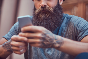 A handsome hipster male with a stylish beard and a tattoo on his