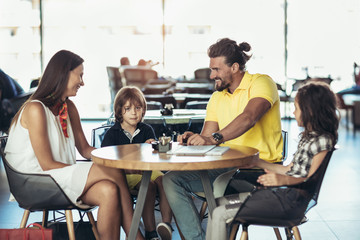  Family with two children having great time in a cafe after shopping