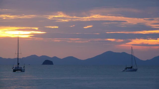 Yachts in the roadstead at sunset. Mountains on the background. Long shot