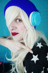 Chica joven con el pelo rubio platino escuchando música con sus auriculares 