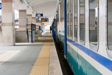 Horizontal View of a Train Stopped in a Railway Station on Blur Silhouette of a Man Background