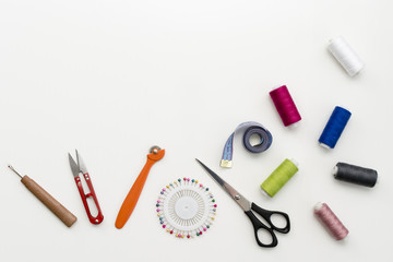 Tailor's work desk. Pattern of sewing accessories and tools on white background top view copyspace